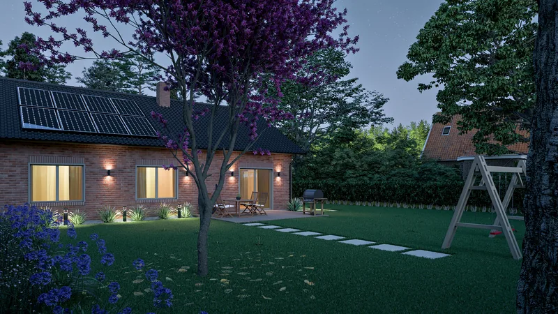 Garten mit Baum und beleuchtetem Haus am Abend